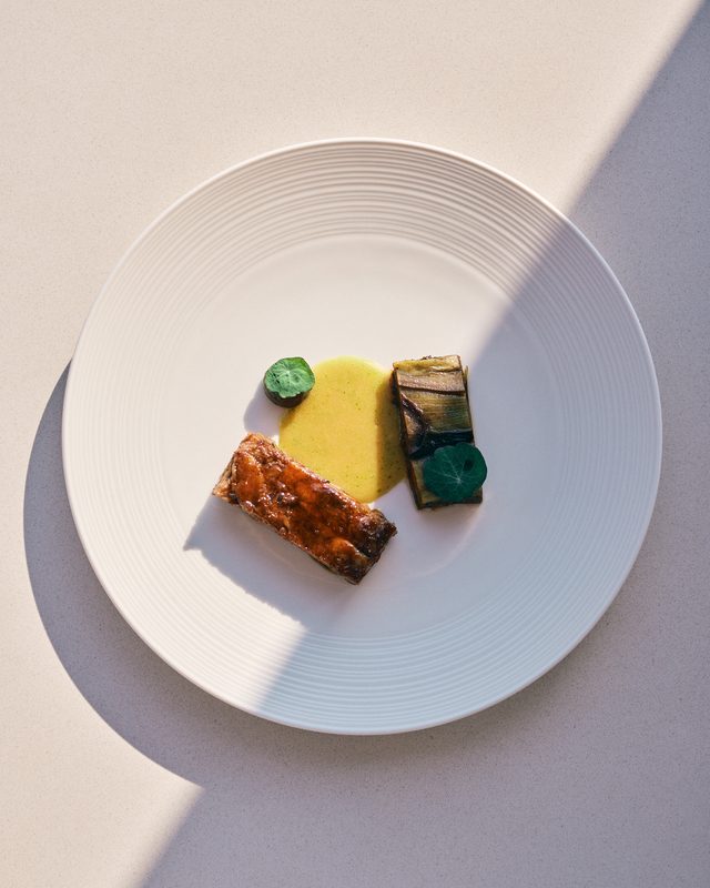 The lamb with aubergine terrine, smoked purée and herb oil, a diagonal shadow across the plate