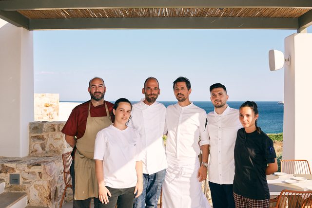 The two kitchen teams together on the terrace before service, the sea behind them